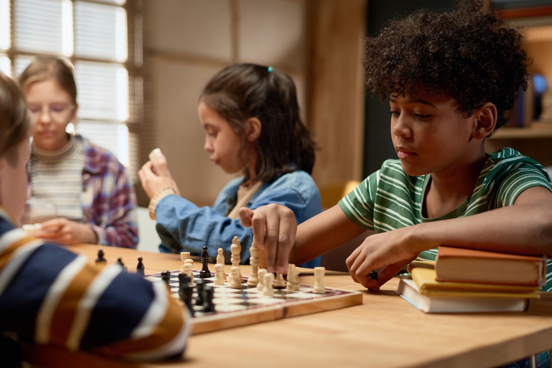 Serious boy moving pawn on chess board