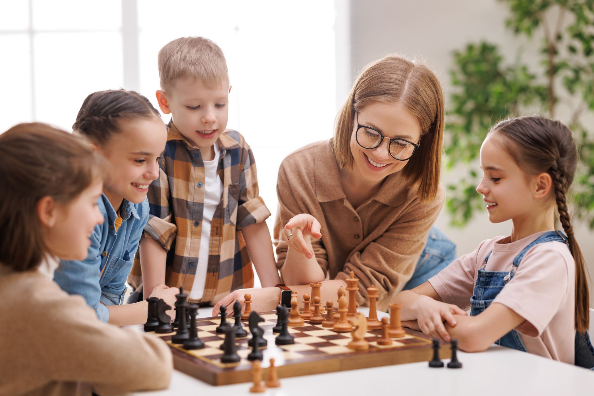 Woman teaching kids to play chess